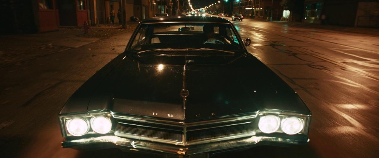 a car parked on the side of a street at night