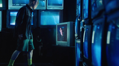 a man standing in front of a television in a dark room