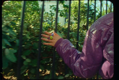 a woman in a purple jacket holding a green object