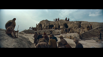 a group of people standing on top of a rocky hillside