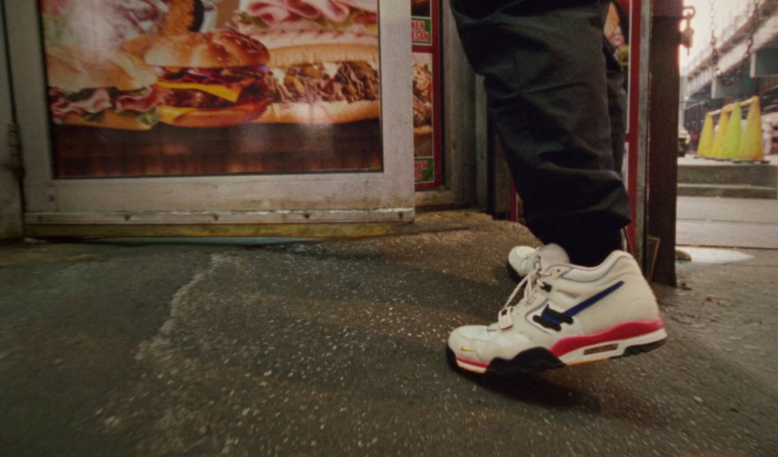 a person standing on a sidewalk with their foot on a shoe