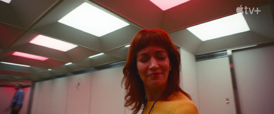 a woman in a yellow shirt is standing in a room