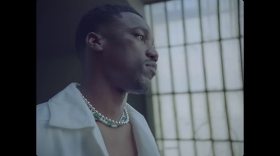 a man in a white shirt wearing a necklace