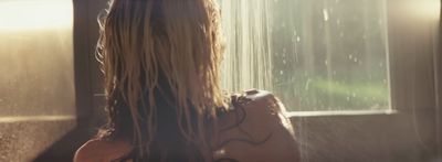 a woman with long hair standing in front of a window