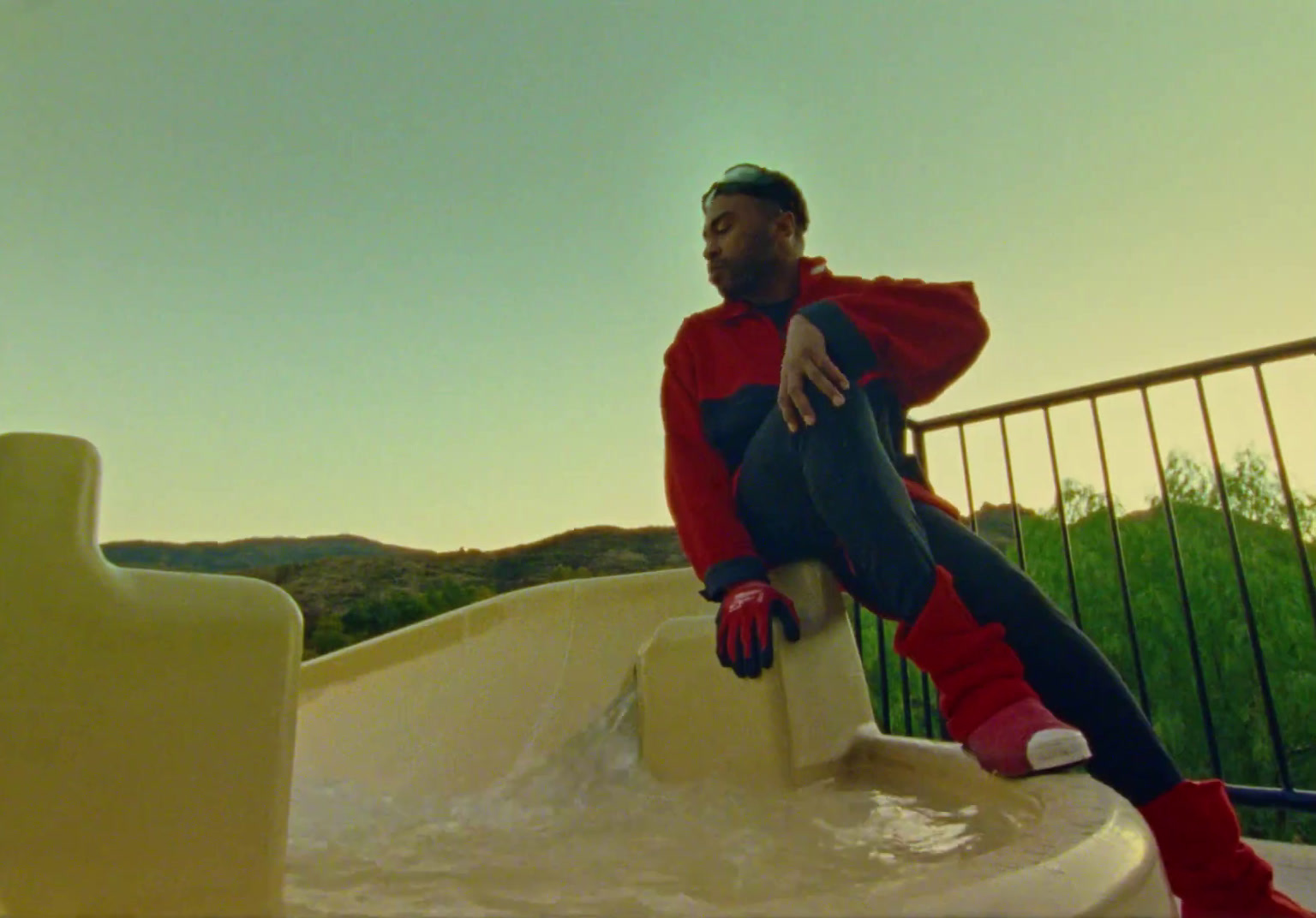 a man in a red and blue outfit sitting on a ledge