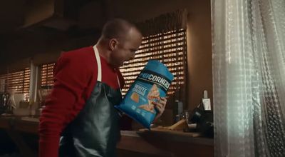 a man in a red sweater is holding a bag of cereal