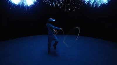 a man is spinning a circle with fireworks in the background