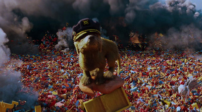 a teddy bear standing on top of a box surrounded by confetti