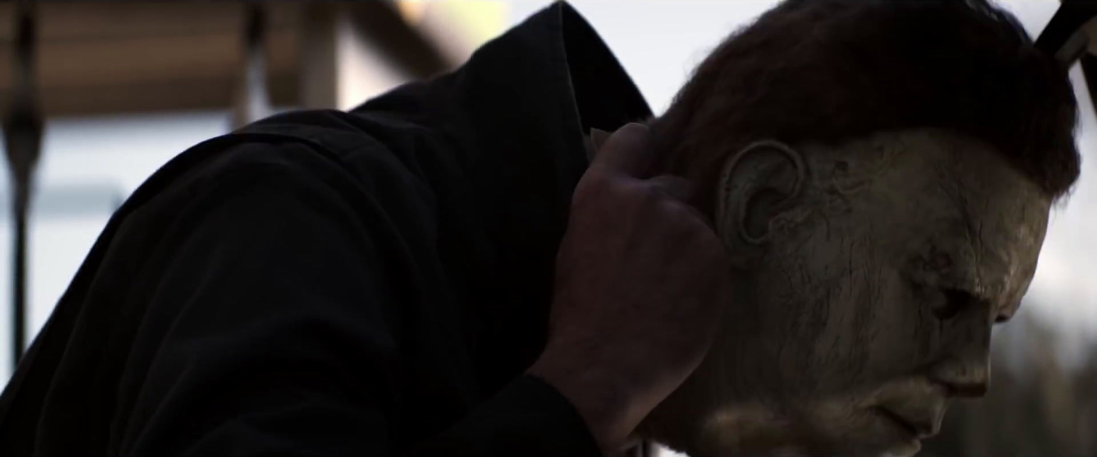 a person with a creepy mask on talking on a cell phone