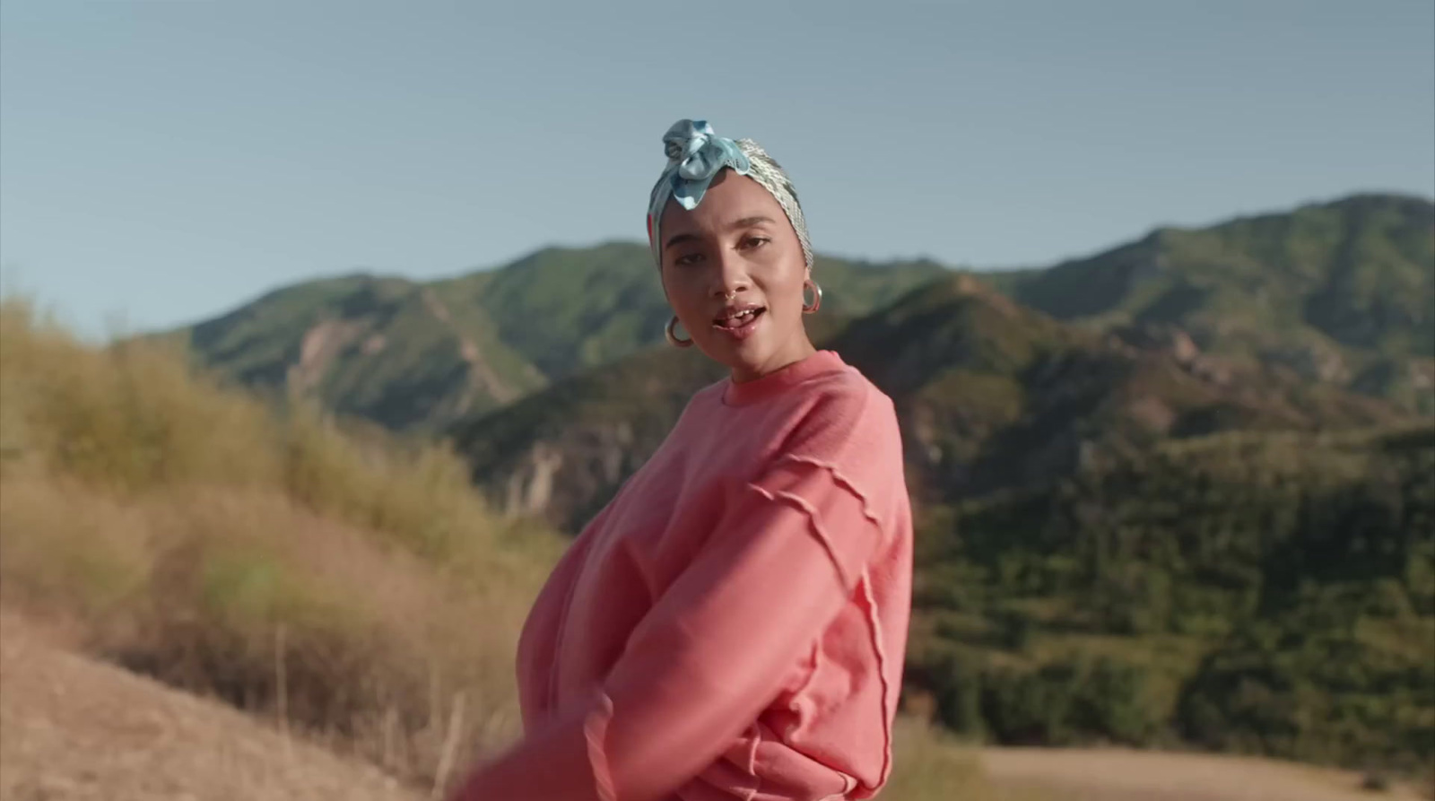 a woman in a pink shirt and a blue head scarf