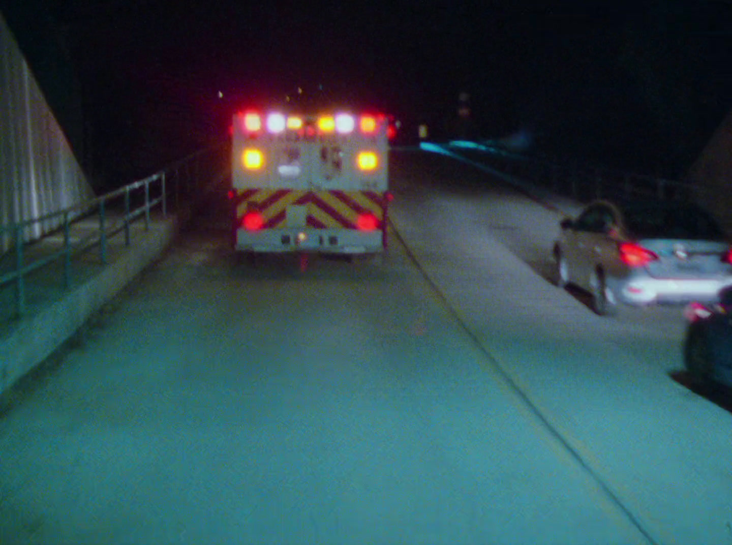 a fire truck driving down a street at night