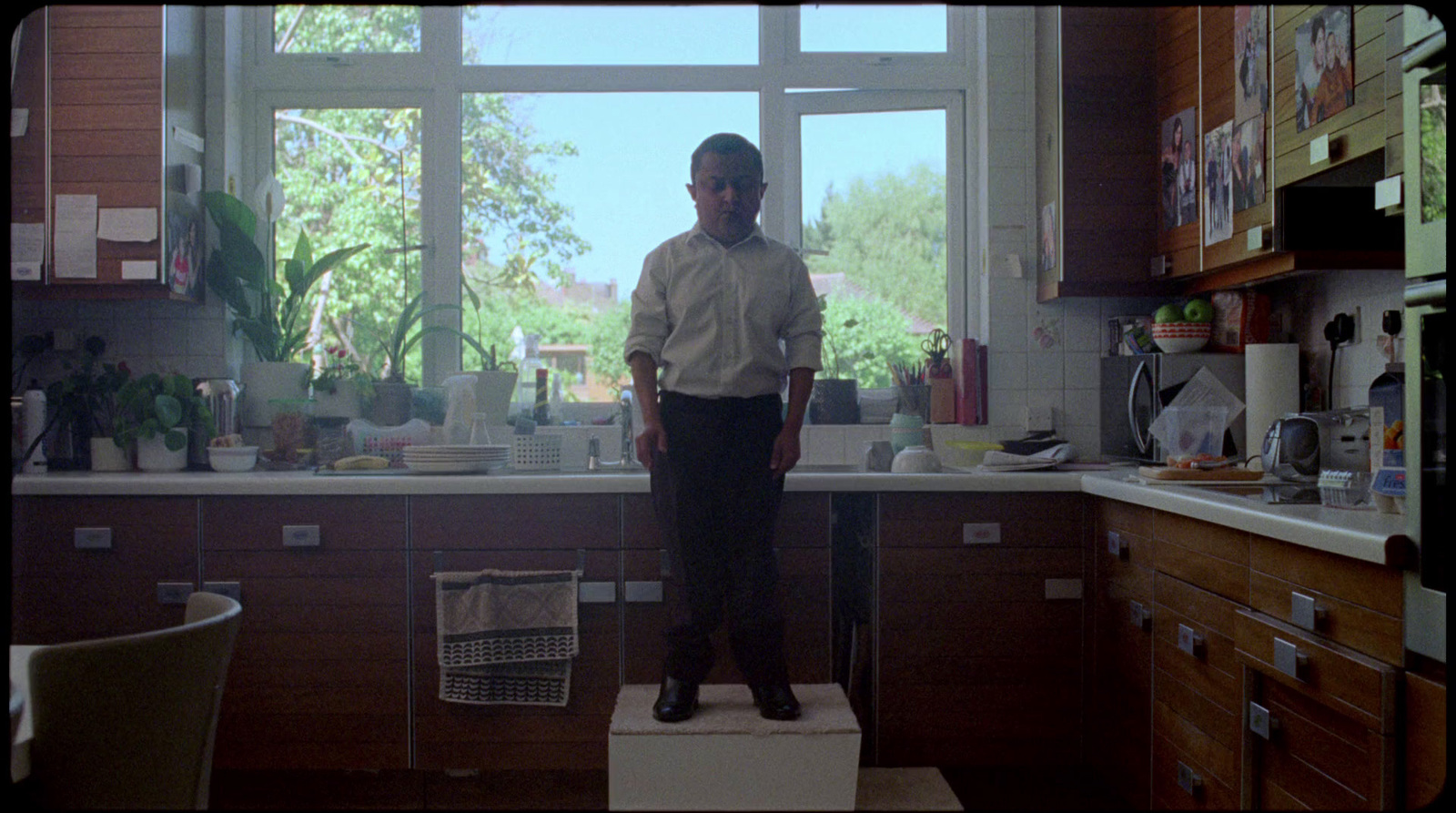 a man standing on a scale in a kitchen