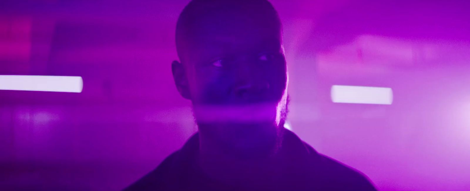 a man standing in front of a purple light