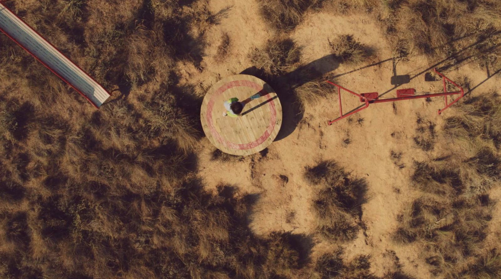 an aerial view of a clock in a field