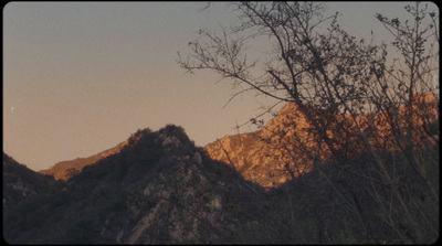 a view of the top of a mountain with trees in the foreground