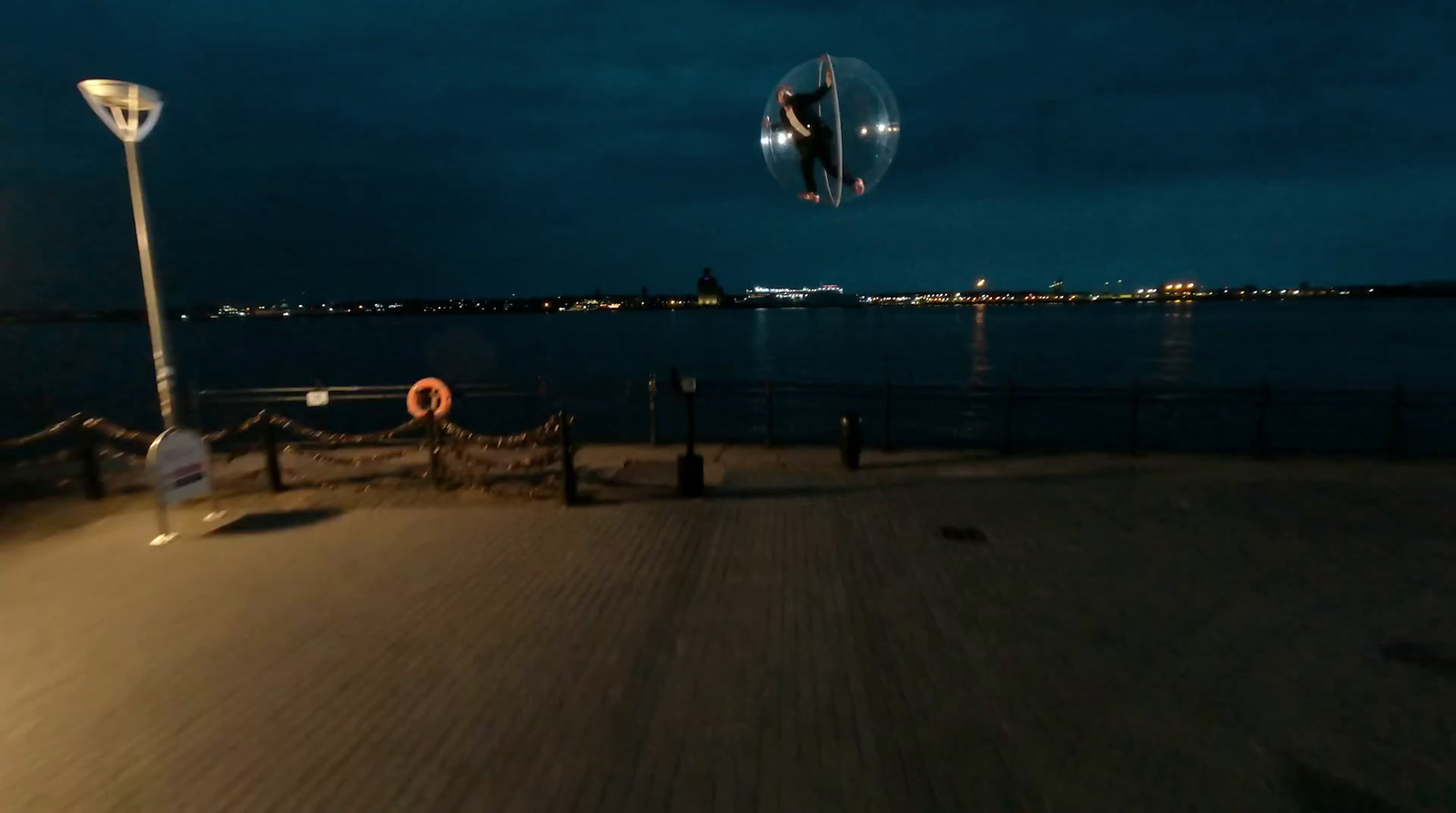 a person flying a kite at night over a body of water