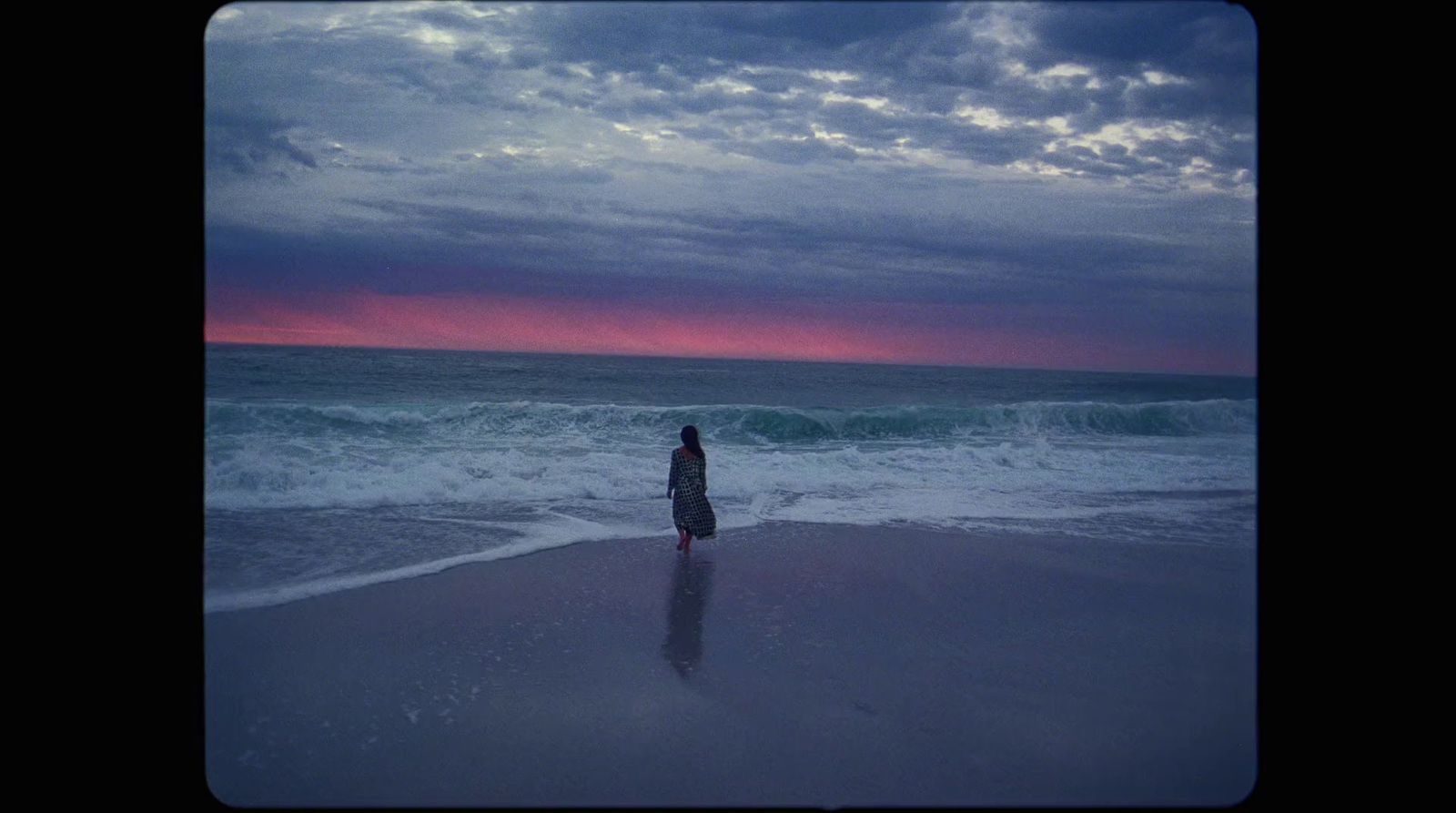 a person standing on a beach next to the ocean