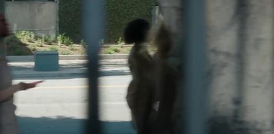 a man standing next to a woman behind a fence