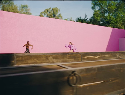 a couple of people that are standing on a pink wall