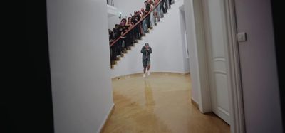 a woman is walking down a staircase with a group of people