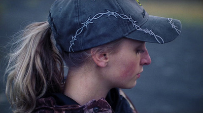 a woman with a ponytail wearing a baseball cap