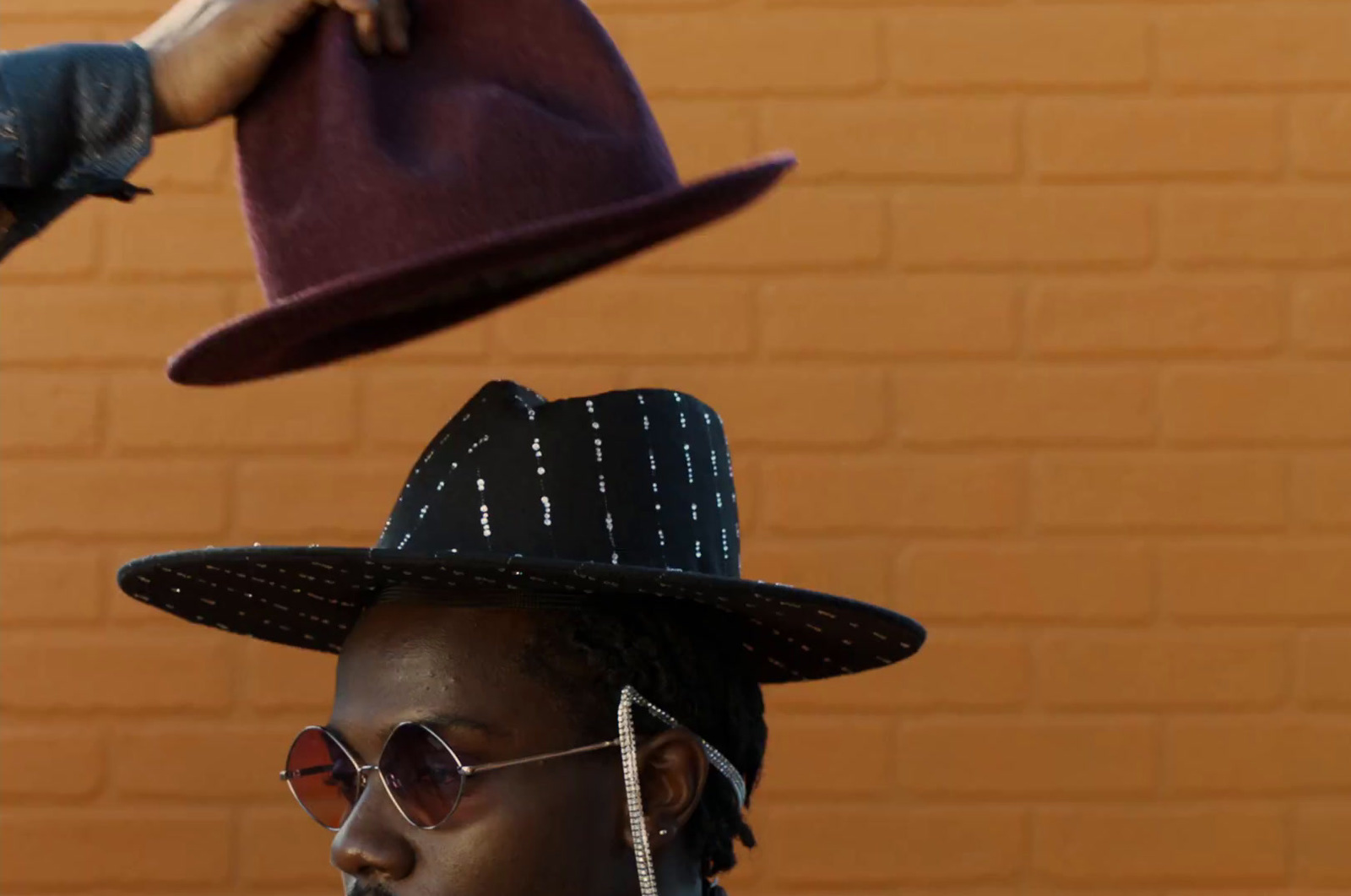 a man wearing a hat and sunglasses