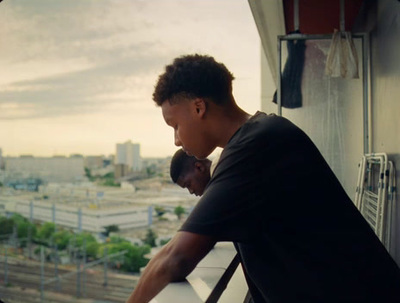 a man leaning against a window looking out at a city