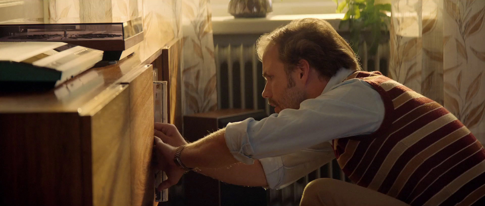 a man sitting at a desk opening a drawer