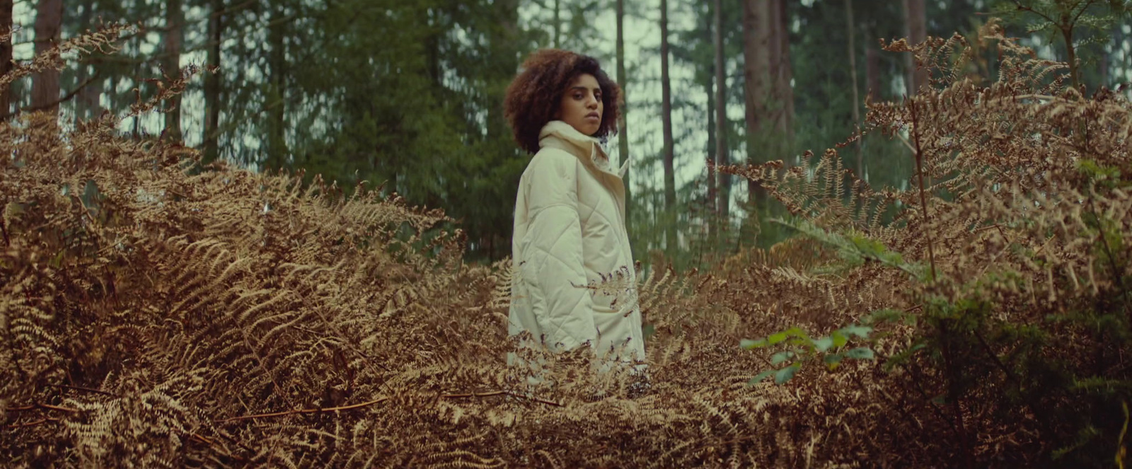 a woman standing in a field of tall grass