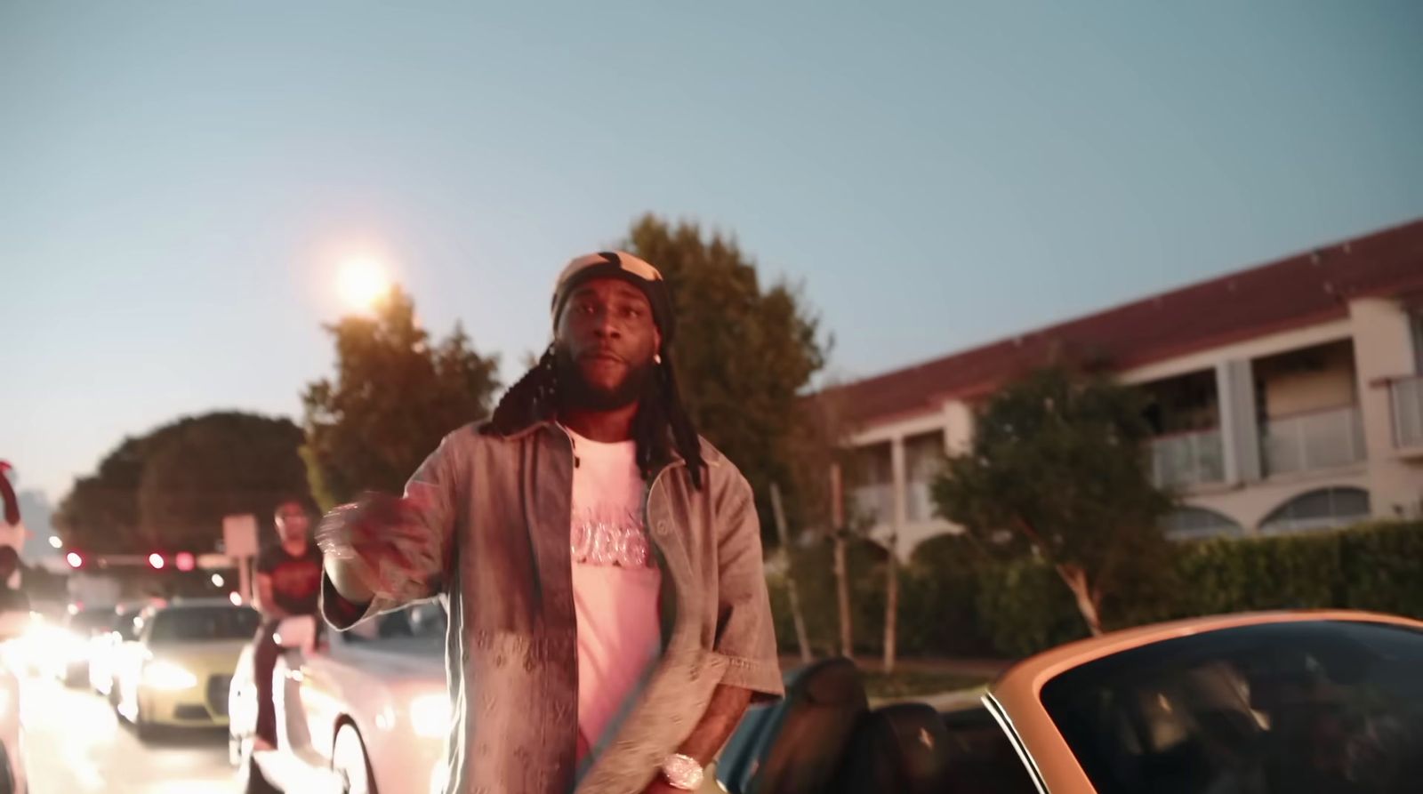 a man standing next to a car in a parking lot