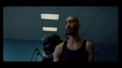 a man in a black tank top standing in a room