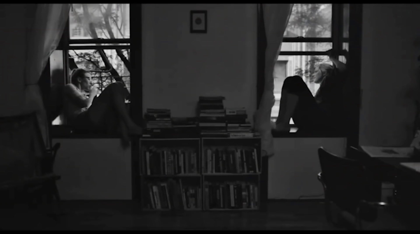 a black and white photo of people looking out a window