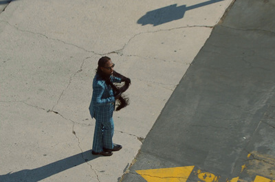 a woman standing on a sidewalk talking on a cell phone