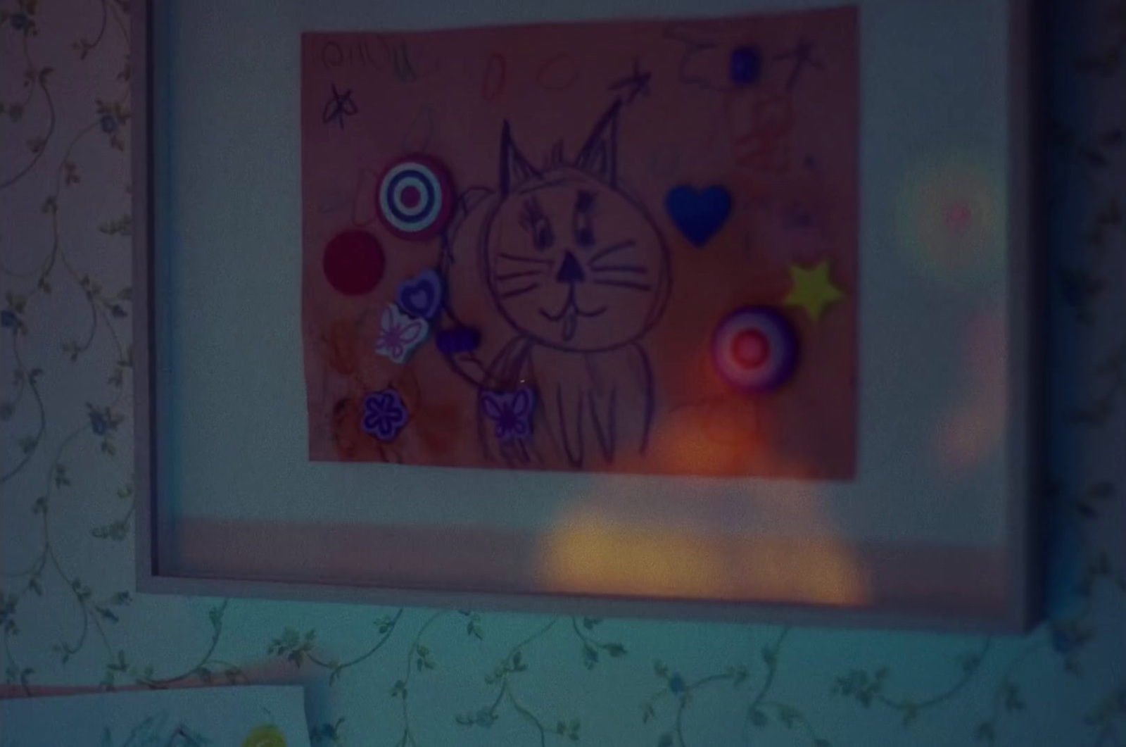 a picture of a cat is hanging on a wall