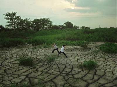 a couple of men standing on top of a dry grass field