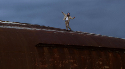 a man standing on top of a rusted metal roof