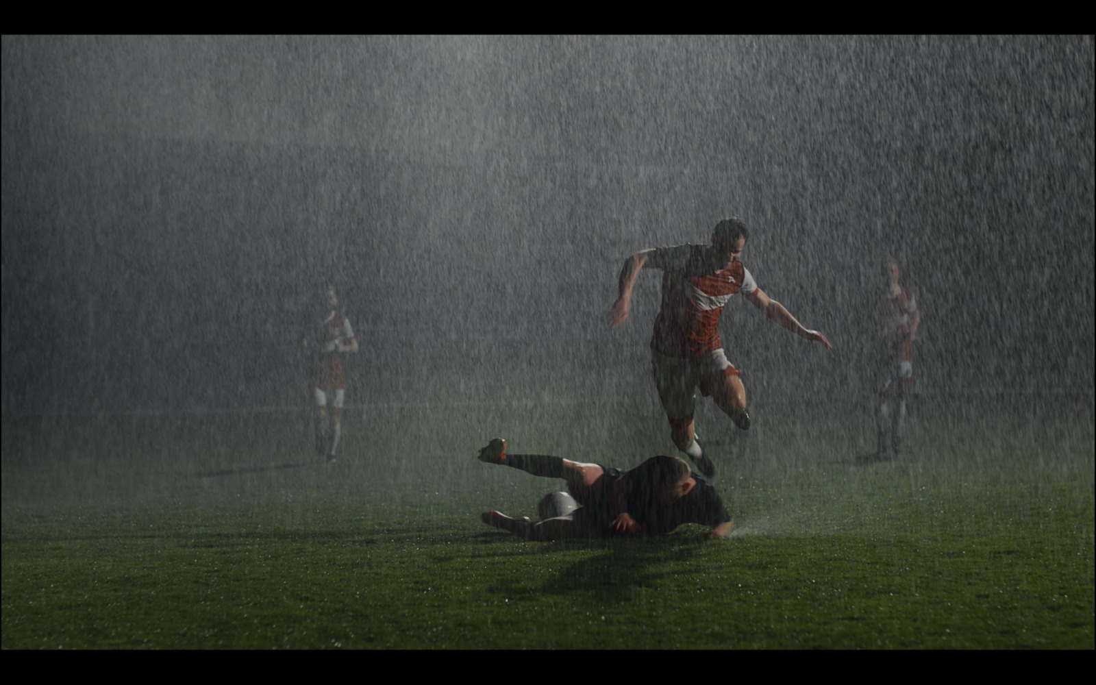 a group of men playing a game of soccer in the rain