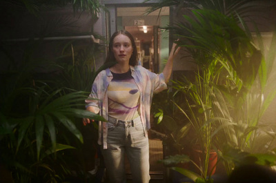 a woman standing in front of some plants