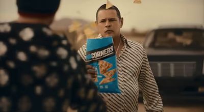 a man holding a box of cornflakes in his hand