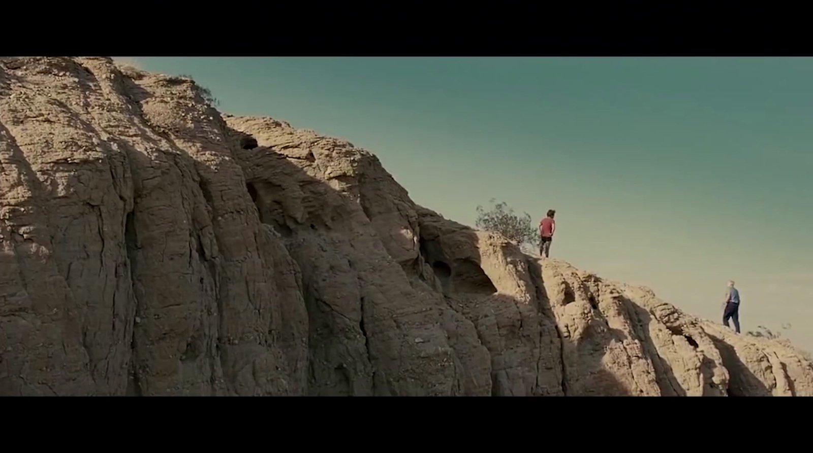 a couple of people standing on top of a mountain