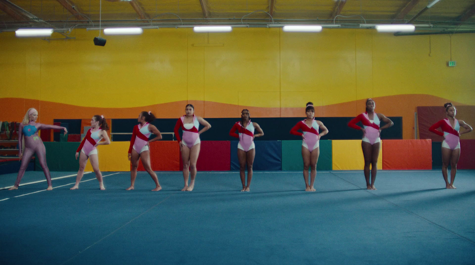 a group of women standing on top of a blue floor