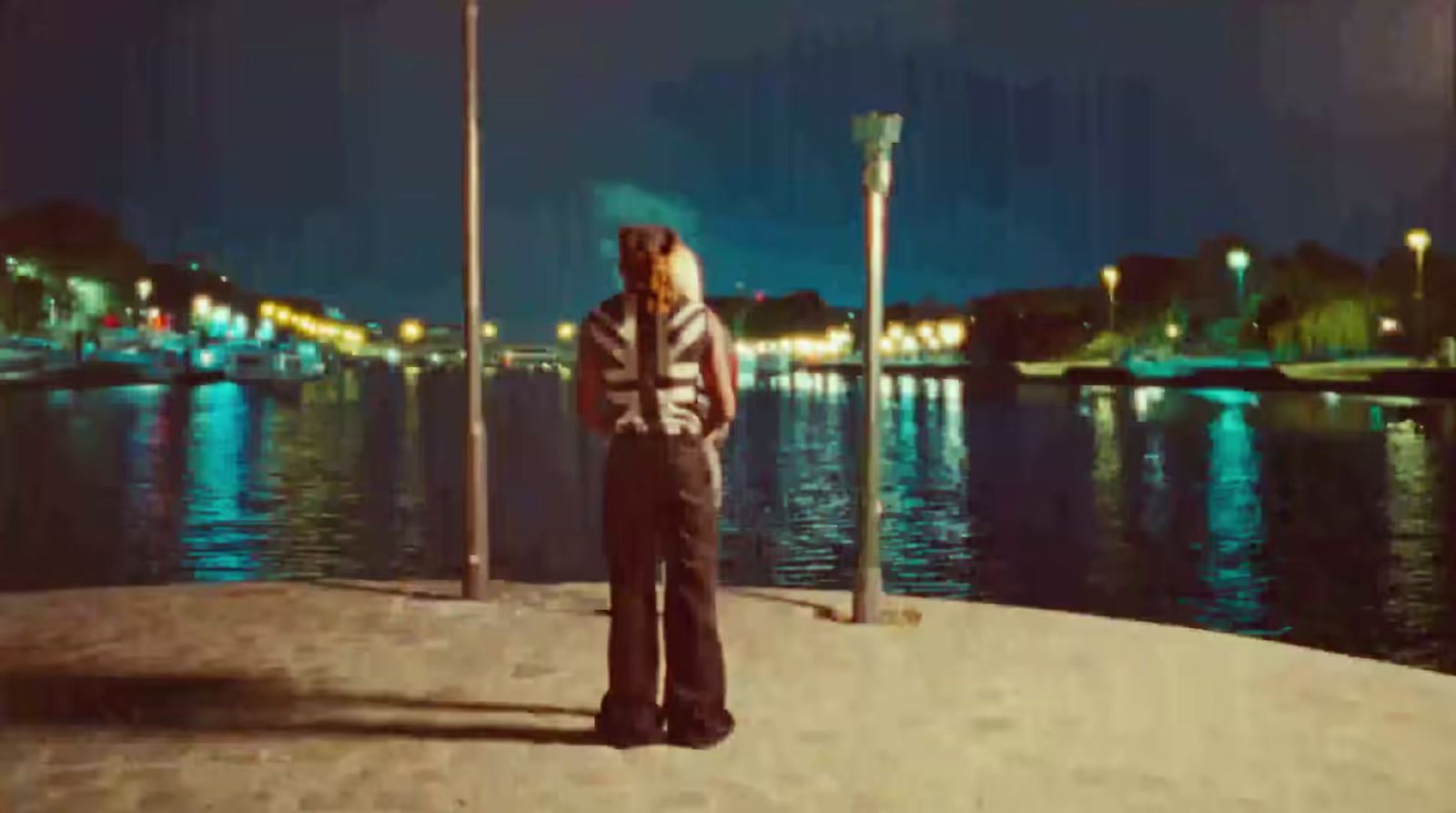 a man standing on a beach next to a body of water