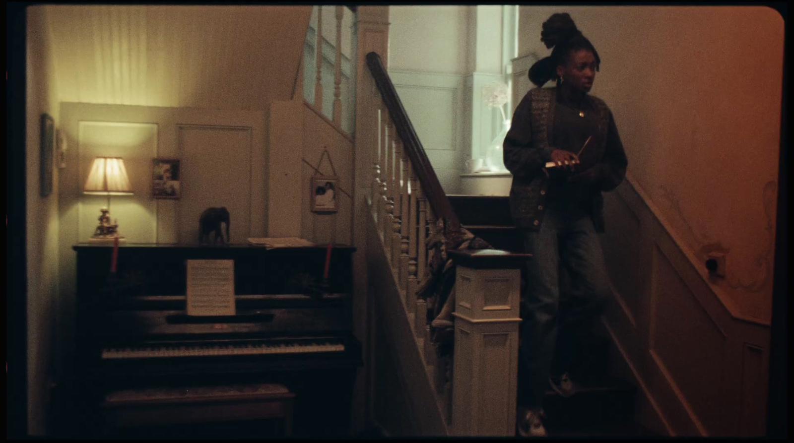 a man standing on a stair case next to a piano