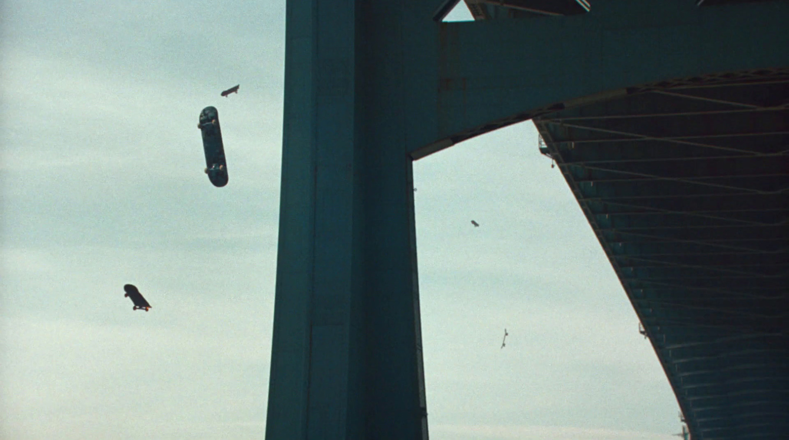 kites are flying in the air near a bridge