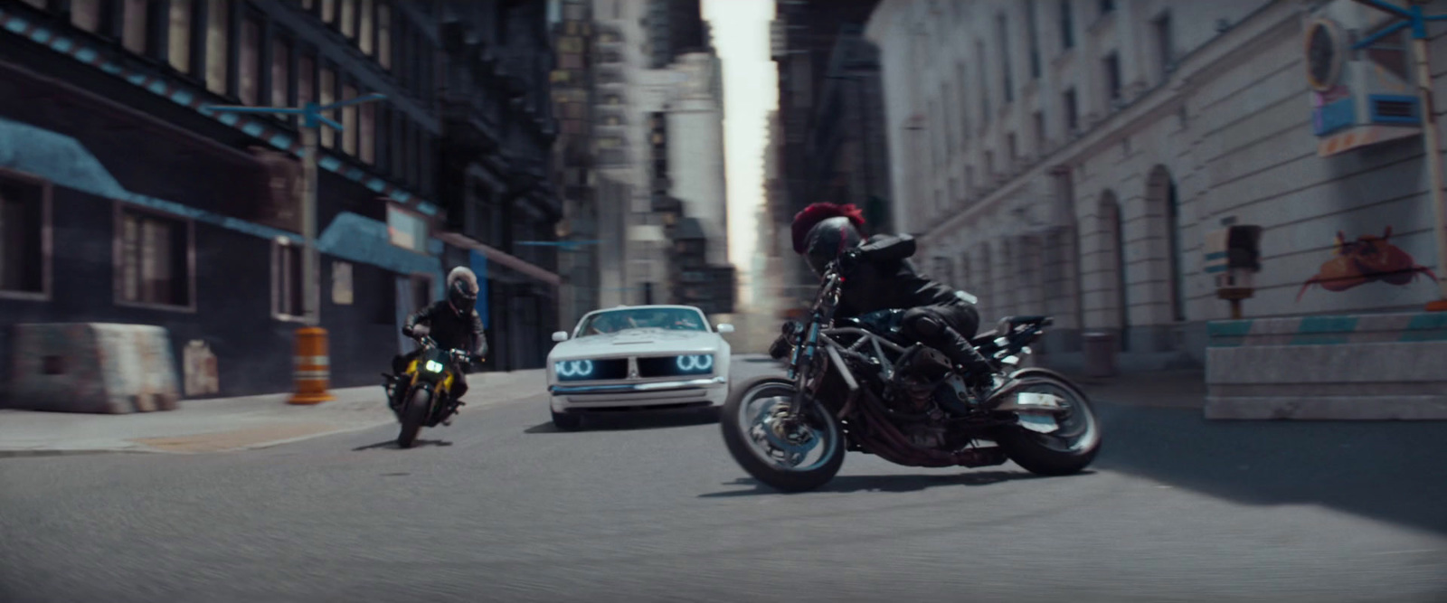 two people riding motorcycles on a city street