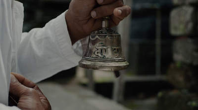 a close up of a person holding a bell