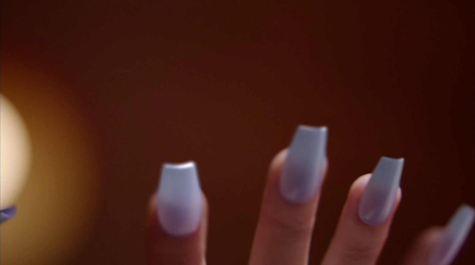 a woman's hand with a white manicure on it