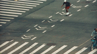 a man riding a bike down a street next to a cross walk