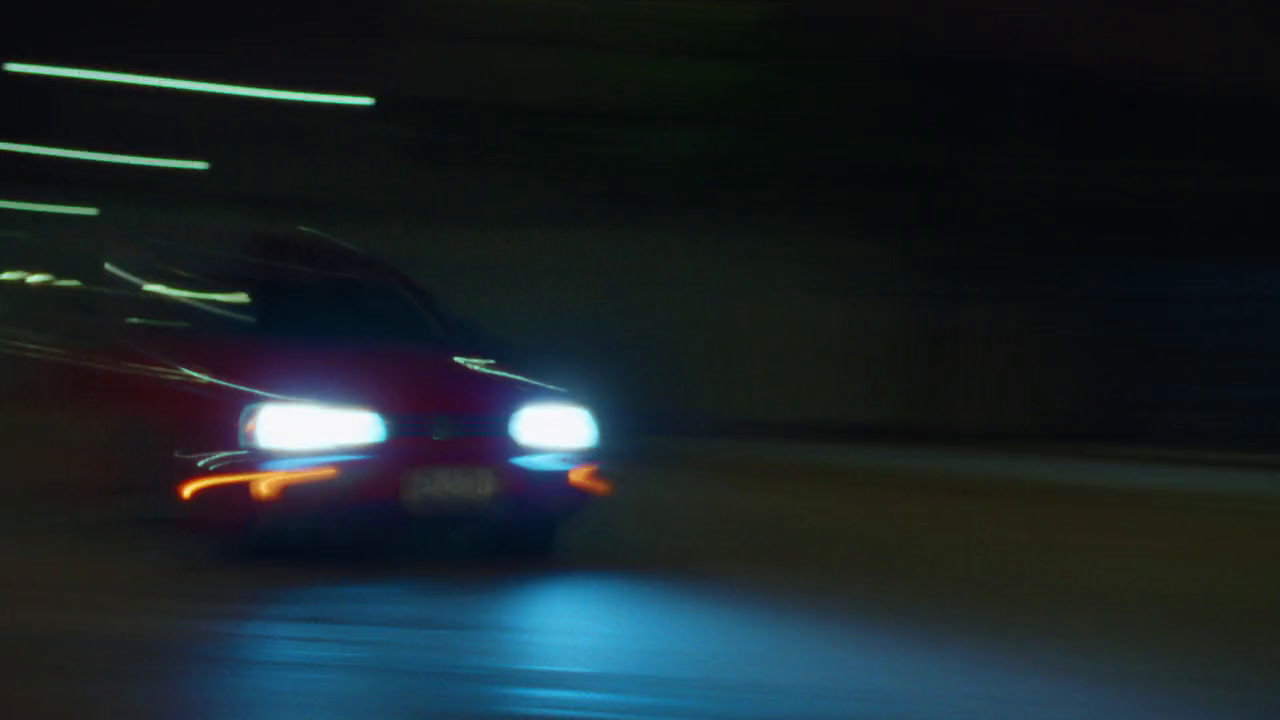 a car driving down a street at night