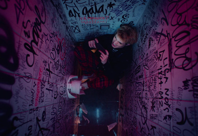 a man sitting on a chair in a room covered in graffiti